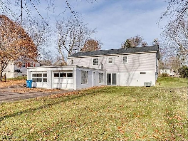 back of property featuring a yard, a sunroom, and central AC