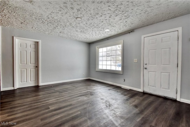 foyer entrance featuring dark wood-type flooring and a textured ceiling