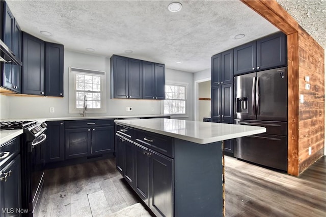 kitchen featuring light hardwood / wood-style floors, stainless steel fridge with ice dispenser, gas stove, and plenty of natural light