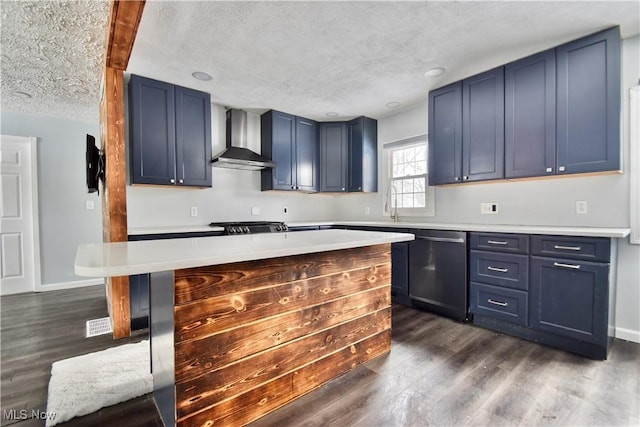 kitchen featuring stainless steel dishwasher, wall chimney range hood, a kitchen island, blue cabinets, and dark wood-type flooring