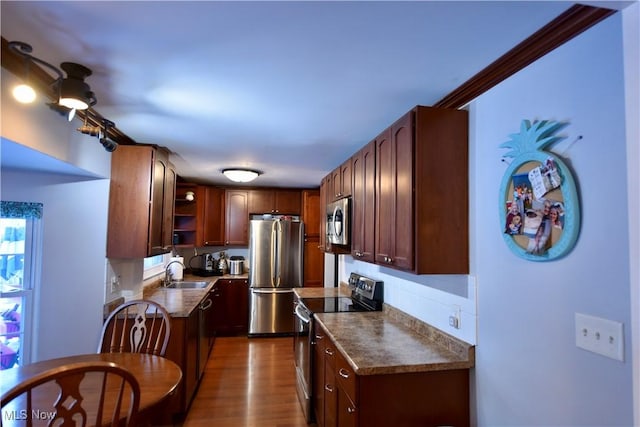 kitchen with sink, hardwood / wood-style floors, appliances with stainless steel finishes, and ornamental molding