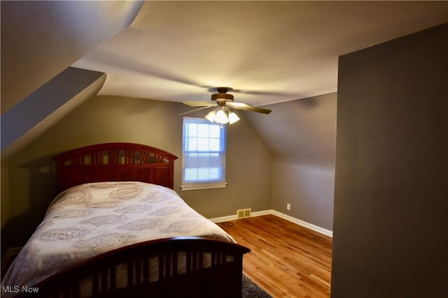 bedroom featuring ceiling fan, wood-type flooring, and lofted ceiling