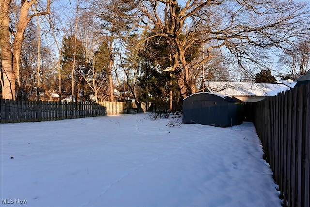 yard covered in snow with a storage unit