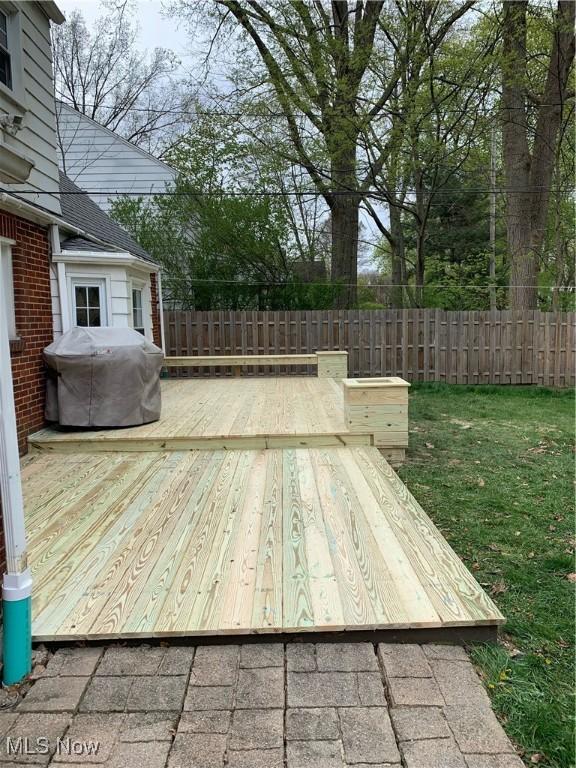 wooden deck featuring a grill