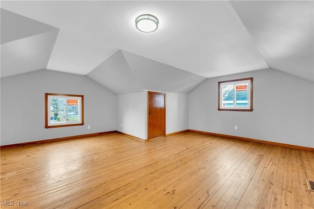 additional living space featuring light wood-type flooring and lofted ceiling