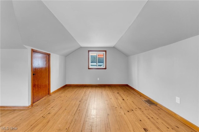 additional living space featuring light hardwood / wood-style floors and lofted ceiling