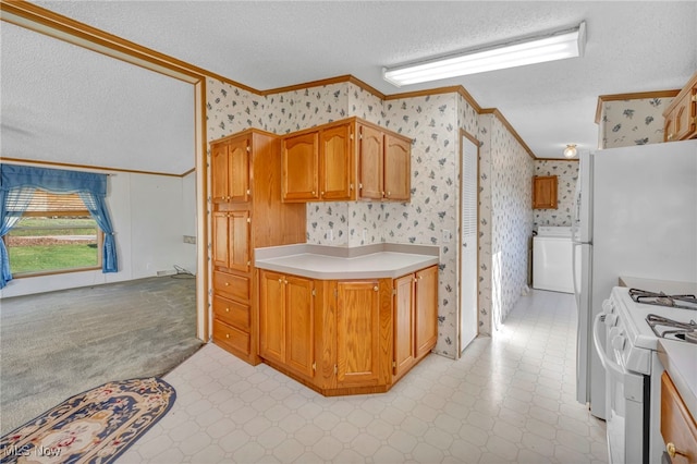 kitchen with white gas stove, washer / dryer, ornamental molding, and a textured ceiling