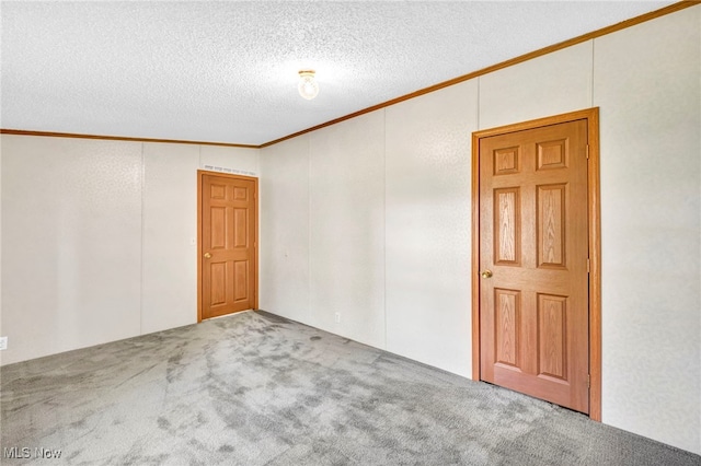 carpeted spare room with ornamental molding and a textured ceiling