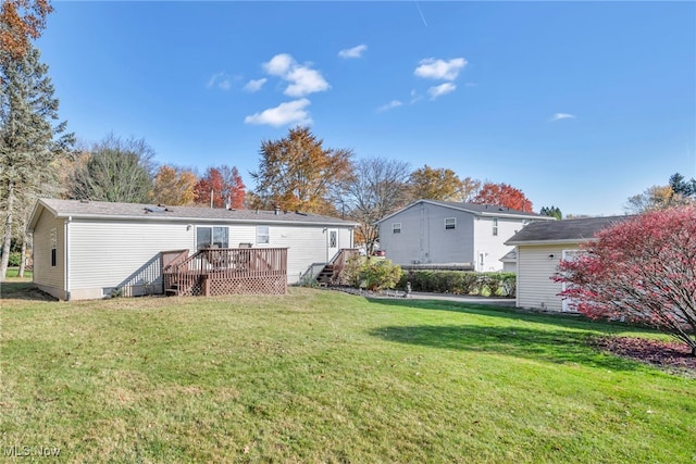 back of house featuring a lawn and a wooden deck