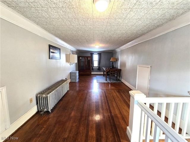 hall featuring dark wood-type flooring, ornamental molding, and radiator