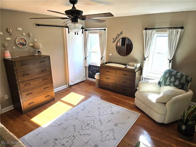 living area with dark hardwood / wood-style floors and ceiling fan