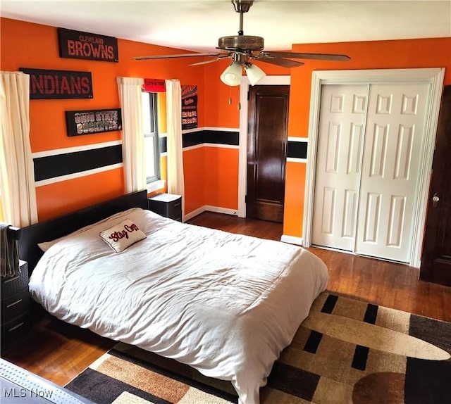 bedroom featuring dark wood-type flooring, ceiling fan, and a closet