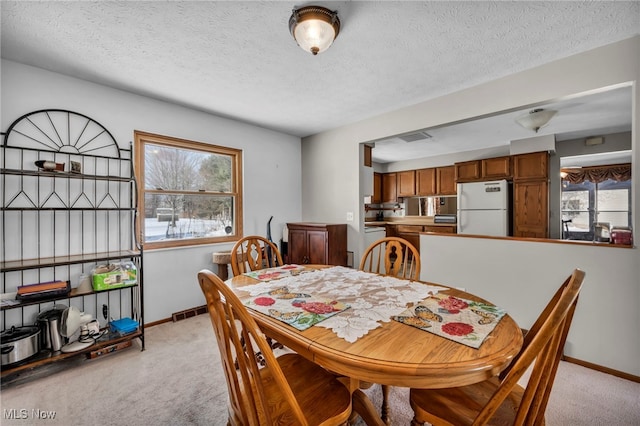 carpeted dining space featuring a textured ceiling