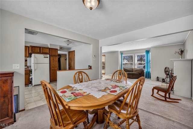 carpeted dining room featuring a textured ceiling