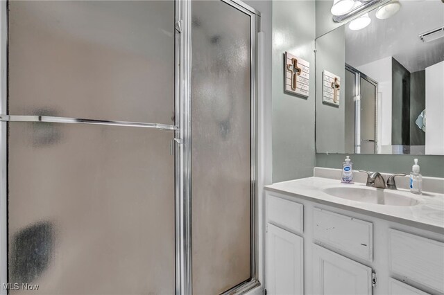 bathroom with a shower with door and vanity