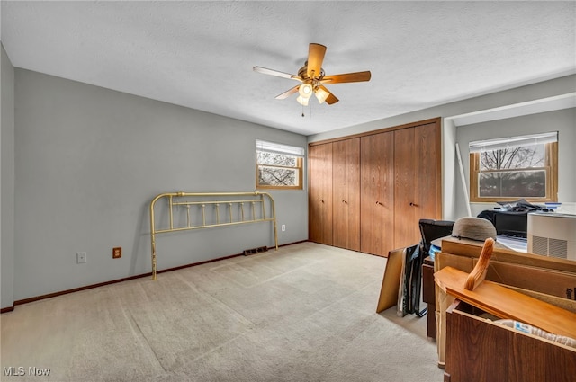 office area with light carpet, a textured ceiling, and ceiling fan