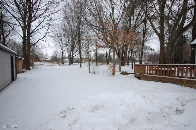 yard covered in snow with a deck