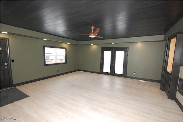 unfurnished living room with wood ceiling, light hardwood / wood-style floors, and french doors