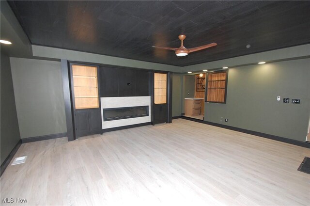 unfurnished living room with ceiling fan, light hardwood / wood-style floors, and wooden ceiling