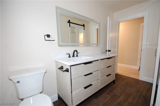 bathroom featuring hardwood / wood-style flooring, vanity, and toilet