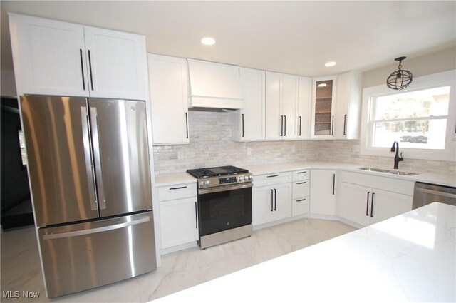 kitchen featuring stainless steel appliances, sink, decorative backsplash, and white cabinets