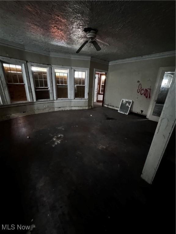 unfurnished room featuring ceiling fan, ornamental molding, and a textured ceiling