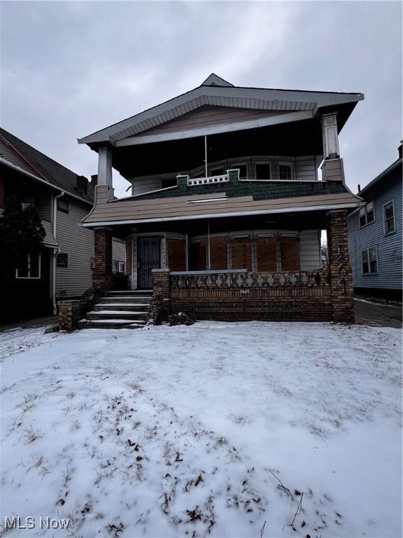 snow covered house with covered porch