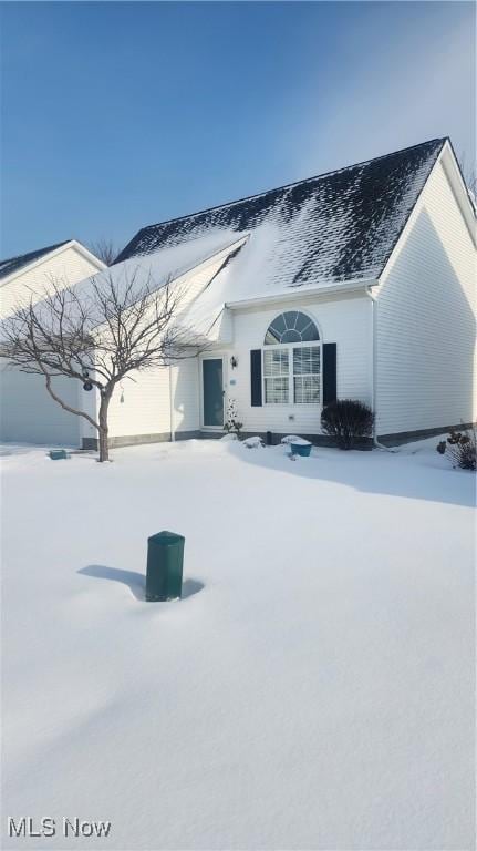 snow covered property with a garage