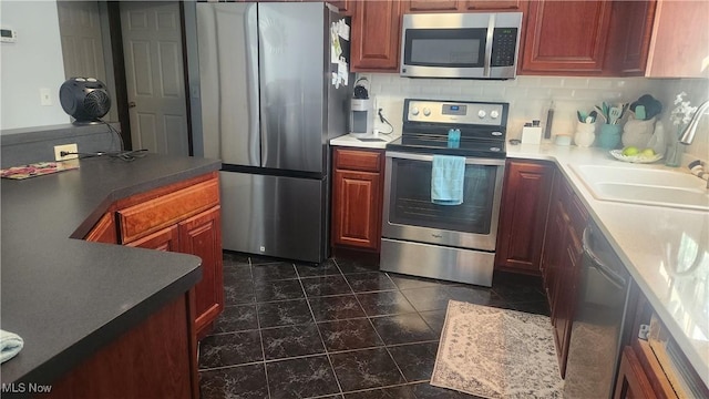 kitchen with appliances with stainless steel finishes, sink, and decorative backsplash