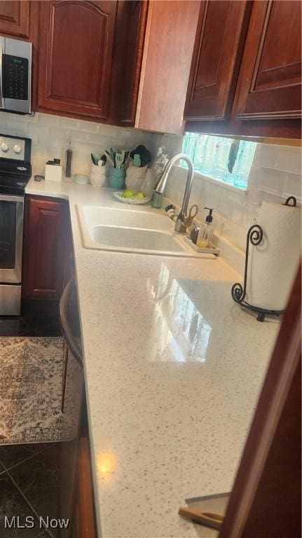 kitchen with stainless steel appliances, sink, and decorative backsplash