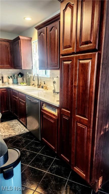 kitchen featuring tasteful backsplash, sink, and stainless steel dishwasher