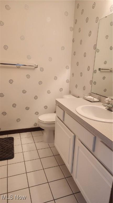 bathroom featuring vanity, tile patterned floors, and toilet