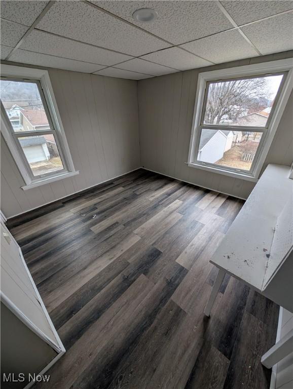 unfurnished room featuring a paneled ceiling and dark hardwood / wood-style flooring