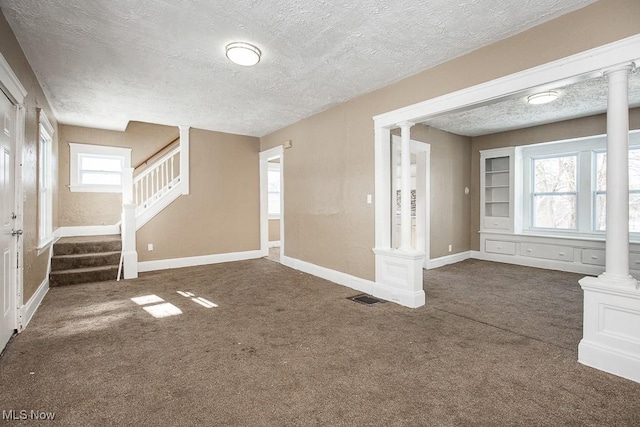 interior space featuring decorative columns and a textured ceiling