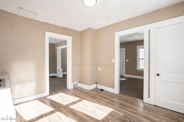 unfurnished room featuring hardwood / wood-style floors and a textured ceiling