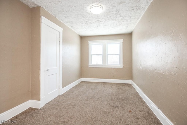 carpeted spare room with a textured ceiling