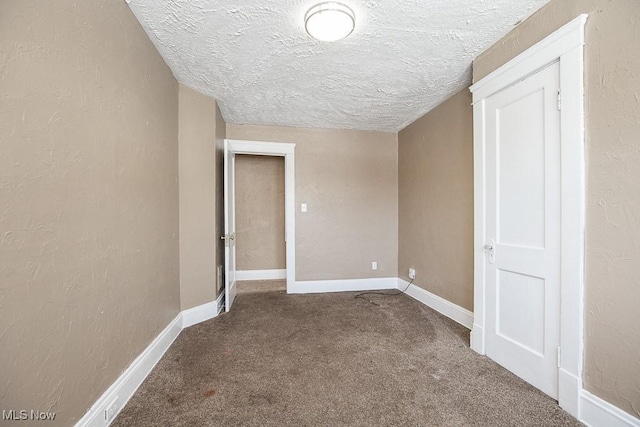 carpeted spare room with a textured ceiling