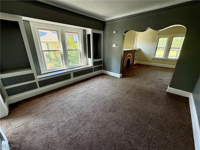 interior space featuring a brick fireplace and dark carpet