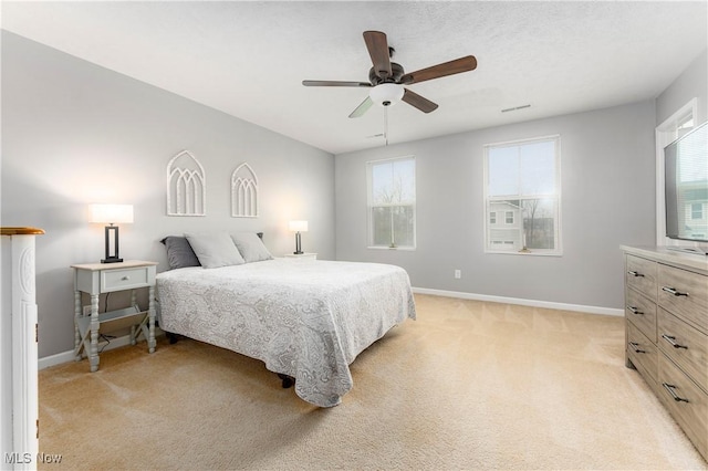 carpeted bedroom with multiple windows and ceiling fan