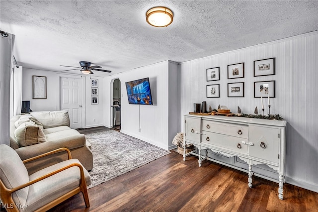 living room featuring a textured ceiling, dark hardwood / wood-style floors, and ceiling fan