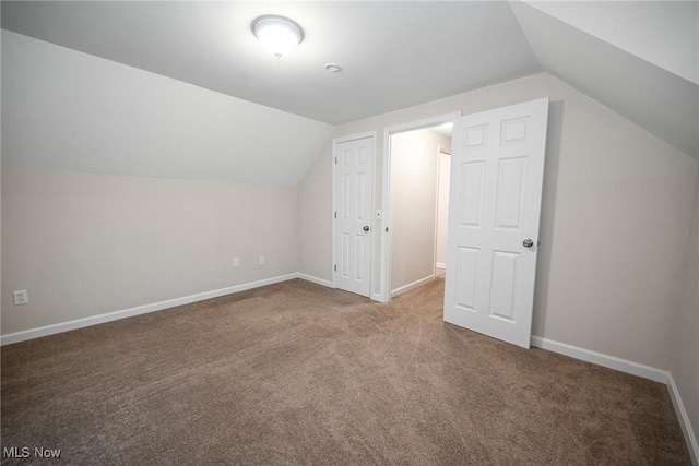 bonus room with lofted ceiling and carpet