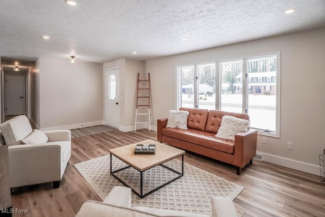 living room with light wood-type flooring and a textured ceiling