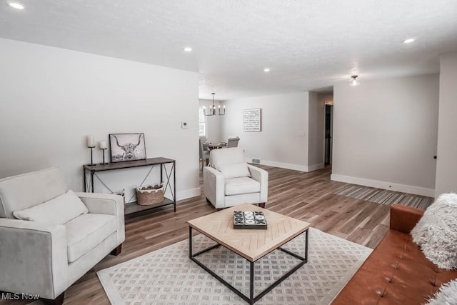 living room with an inviting chandelier and hardwood / wood-style floors