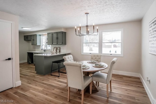 dining room with sink, an inviting chandelier, dark wood-type flooring, and a textured ceiling