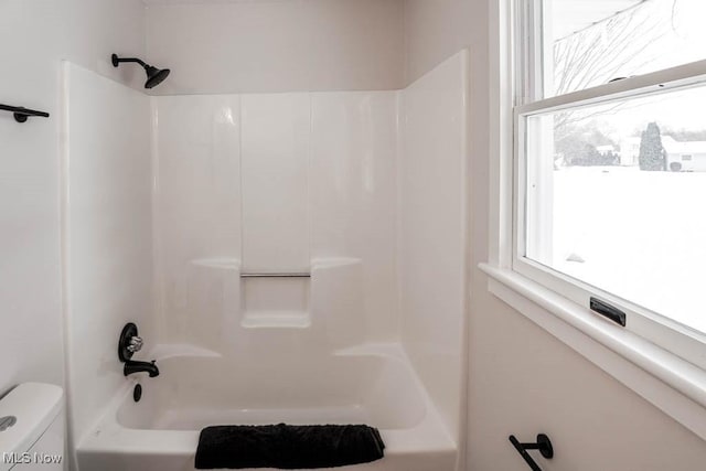 bathroom featuring toilet and bathing tub / shower combination