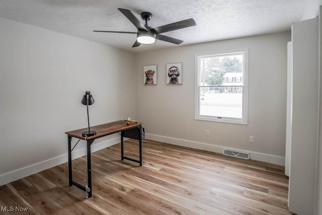 office area featuring light wood-type flooring, a textured ceiling, and ceiling fan