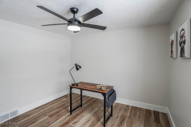 office with ceiling fan and light hardwood / wood-style flooring