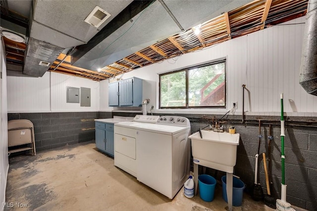 washroom featuring sink, separate washer and dryer, and electric panel