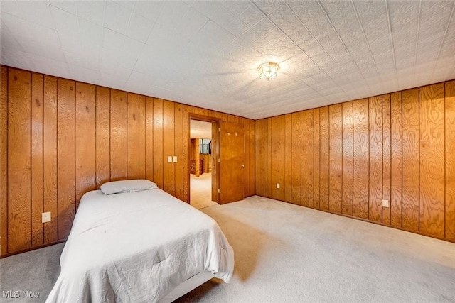 carpeted bedroom with wooden walls