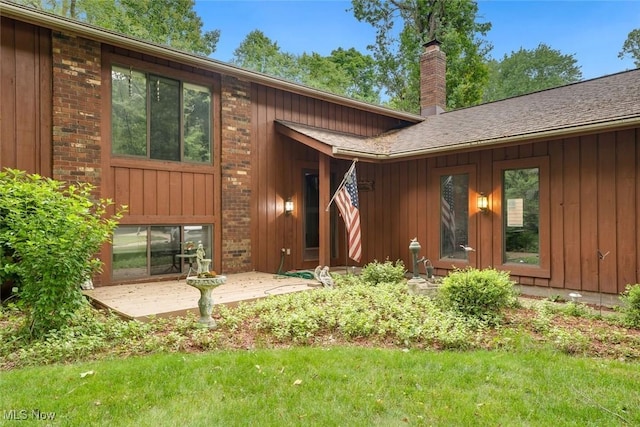 rear view of house with a lawn and a patio